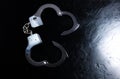 Police metal real handcuffs on the black background. Crime and robbery, prison concept