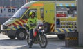 Police motorcyclist with ambulance in the background
