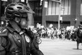 Police office in body armor watches crowd of protestors