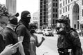 Police officer in body armor faces off with a crowd of protestors