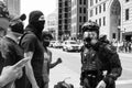 Police officer in body armor stands in front of a crowd of protestors