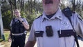 Police officer confronts camera man crime scene tape at a vintage vacant strip mall Meadowbrook dr Richmond County Sheriffs