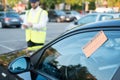 Police officer giving a fine for parking violation Royalty Free Stock Photo