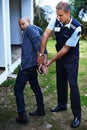 Police officer, handcuffs and outdoor to arrest man for crime with safety, protection or security. People, law Royalty Free Stock Photo