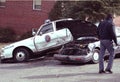 A police officer looks at a auto accident involving a police car