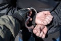 A police officer puts handcuffs on the hands of a bandit