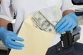 Police Officer Putting Money In Evidence Envelope