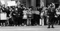 A police officer stands in front of a line of protestors who have linked arms in downtown Columbus Ohio