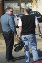 Police officer talking with a television cameraman while