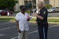 A police officer talks to an African American at a community events Royalty Free Stock Photo