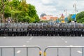 Police officer team with weapons and riot shield protection. Violence Against Demonstrators and protesters with barrier fence.