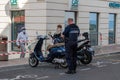 A police officer writes a fine to two misplaced scooters