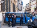 Police officers and Gendarmerie or military police in front of a van in the old town center,