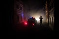 Police raid at night and you are under arrest concept. Silhouette of handcuffs with police car on backside. Image with the