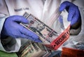 Police scientist examines dollar stolen from crime lab heist