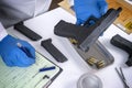 Police scientist examines firearm involved in murder at crime lab