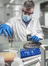 Police scientist is holding scissors in beaker in crime lab