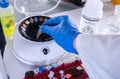 Police scientist inserts vial into microcentrifuge in crime lab