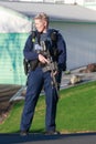 A female member of the New Zealand police, armed and guarding a street
