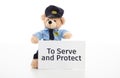 Cute teddy in policeman uniform, to serve and protect text on a paper against white background
