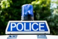 Police sign and blue light on patrol vehicle.