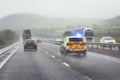 Police siren flashing blue lights on motorway in bad weather conditions