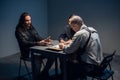 In the police station`s interrogation room, good and bad cops are questioning a theft suspect in a leather jacket. Royalty Free Stock Photo