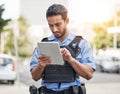 Police, tablet and patrol with a man officer outdoor on the street, using the internet to search during an investigation Royalty Free Stock Photo