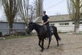 Police trainer leading horse with a horseman in a circle of a manege