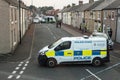 Police with vans close of a street with terraced houses to deal with an incident.  Residential setting Royalty Free Stock Photo