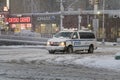 Police vehicle crosses intersection of Bronx New York street during snow storm