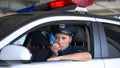 Police woman in car taking on portable radio, informing during area patrolling