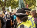 A police woman observes protesters marching at the climate strikes in London