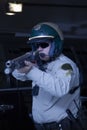 Policeman Aiming Rifle While Standing In Front Of Car