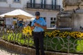 A policeman in the center of Coimbra looks at his smartphone in a relaxed way, nothing happens. A normal working day in