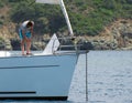 yachtsman raises an anchor on a sailing yacht in a picturesque bay Royalty Free Stock Photo