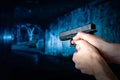 Policeman holding gun in his hand on blur dark subway background. Shooting with a pistol. Royalty Free Stock Photo