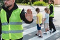 Policeman in a reflective vest raises his hand to stop the car