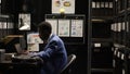 Policeman sits at desk with minicomputer