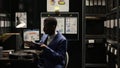 Policeman sits at desk with minicomputer