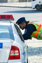 Policeman talking with another one in the car. Cityscape of Budapest.