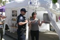 Policeman talks to vendor at her booth