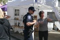 Policeman talks to vendor at her booth