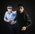 Policeman and thief. Robbery scene. Royalty Free Stock Photo
