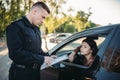 Policeman in uniform writes fine to female driver Royalty Free Stock Photo