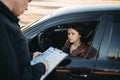 Policeman in uniform writes fine to female driver Royalty Free Stock Photo