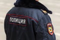 A policeman in winter uniform stands with his back. The inscription `police` on the jacket at the back.