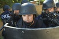 Policemen Aiming Guns While Standing Behind Shield