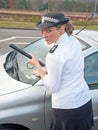 Policewoman deals with badly parked car Royalty Free Stock Photo