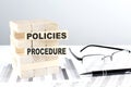 POLICIES PROCEDURE is written on wooden blocks on a chart background